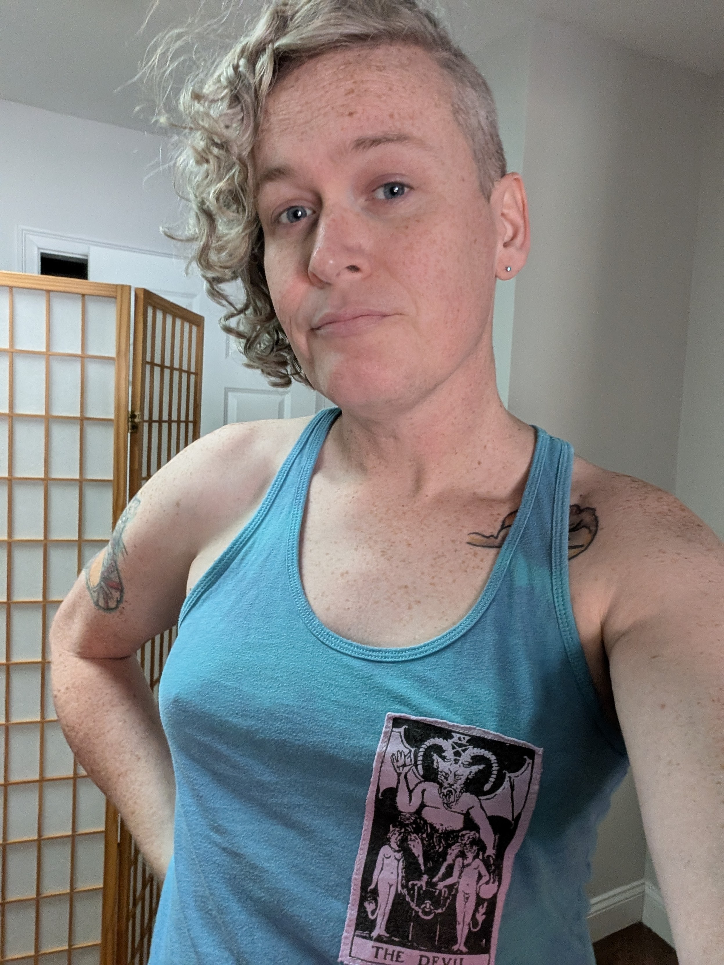 Me looking a little rough wearing a light blue tank with a devil tarot card on it